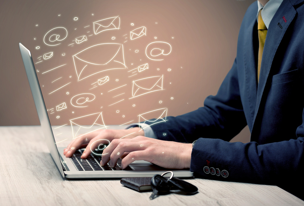 An office worker sending emails and communication with clients with the help of a portable laptop on desk concept